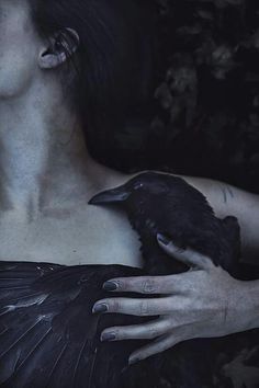 a woman holding a black bird in her hand with the words voge written on it