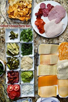 several plates with different types of cheeses and meats on them, along with other foods