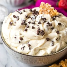 a bowl filled with whipped cream and chocolate chip toppings on top of crackers