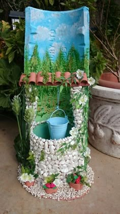 a chair made out of rocks and plants with a bucket in the center on top