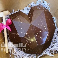 there is a chocolate cake in the box with pink ribbon on it and an umbrella