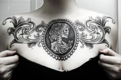 a woman with a skeleton tattoo on her chest is holding up the frame in front of her