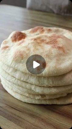 a stack of flat bread sitting on top of a wooden table