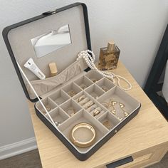 an open jewelry box sitting on top of a wooden table