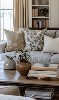 a living room filled with lots of furniture and books on top of a coffee table