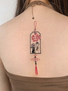 the back of a woman's shoulder with a cat and flowers tattoo on it