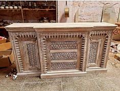 an old wooden cabinet with intricate carvings on the front and sides, in a shop