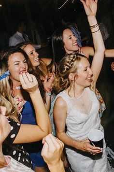 a group of young women standing around each other at a party with confetti in their mouths