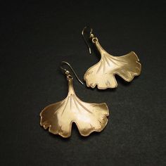 "Hand sculpted ginkgo leaf earrings. Ginkgo biloba is a very old species, with some fossils dating back 270 million years. Native to China, the tree is widely cultivated, and was cultivated early in human history. It has various uses in traditional medicine and as a source of food. In Japanese decorative art, the ginkgo's distinctive fan-shaped leaf has carried symbolism along with its singular beauty: the ginkgo has been a symbol of longevity (the tree can live for a thousand years) and of a mo Food In Japanese, Art Nouveau Earring, Gingko Leaves, Ginkgo Biloba, Ginkgo Leaf, Human History, Traditional Medicine, A Thousand Years, Clear Nails