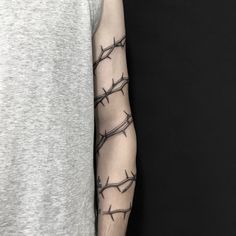 a man's arm with barbed wire tattoo on the left upper arm and shoulder