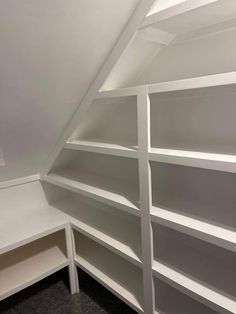 a white bookcase in the corner of a room with two shelves and one shelf