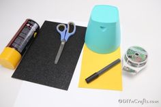 scissors, tape and glue are sitting on top of a piece of paper