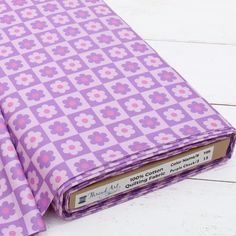 a purple and pink flowered cloth on a white wooden floor