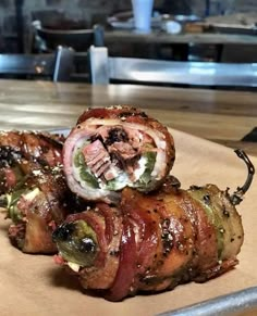 bacon wrapped jalapeno is sitting on top of a cutting board with the caption texas twinkies