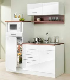 a kitchen with white cabinets and an open refrigerator