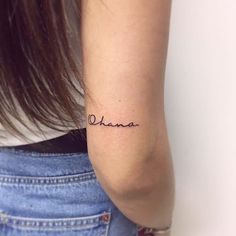 a woman's arm with the word obama tattooed on her left side, in cursive font