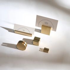 three different types of business cards and magnets on a white surface with shadows from the wall