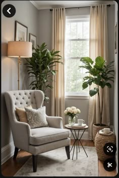 a living room with a chair, table and two potted plants in the corner