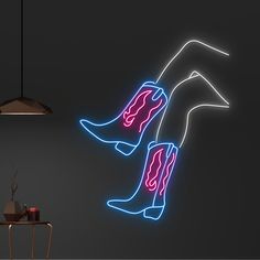 a neon sign that is on the side of a wall next to a table and chair