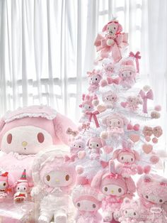 a pink christmas tree with stuffed animals around it