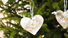 two heart shaped ornaments hanging from a tree