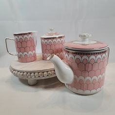 a pink and white tea set with matching cups