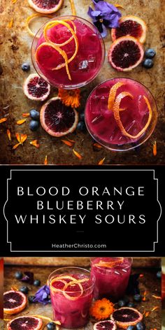 blood orange and blueberry whiskey sours are served in glasses with garnishes