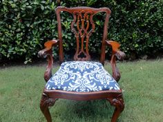 an old wooden chair with blue and white upholstered fabric on it's seat