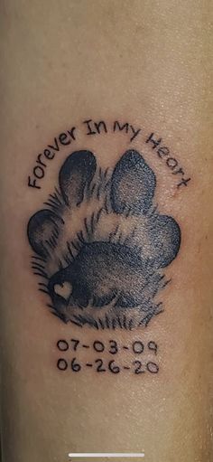 a tattoo on the leg of a person with a dog paw and words that say forever in my heart