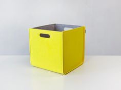 a yellow storage box sitting on top of a white table