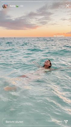 a woman swimming in the ocean at sunset