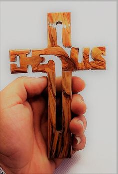 a person holding a wooden cross in their hand