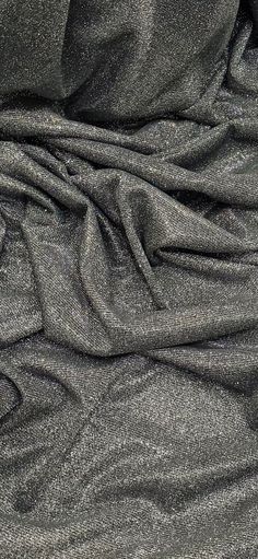 an up close shot of a black fabric with silver glitter on the top and bottom