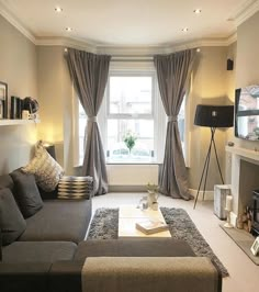 a living room filled with furniture and a flat screen tv mounted on the wall next to a fire place