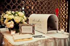 a white table topped with a mailbox and flowers