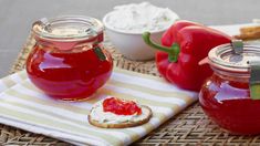 two jars filled with jelly sitting on top of a table next to other food items