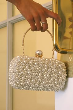 DETAILS: Our Pearl Bead Chic Clutch/Crossbody Bag In White is a outstanding detailed bag with a gold metal strap handle and a alternative metal link crossbody strap. The bag has a big pearl detail closure on the center top and pearl embellishments on the front and a silver shimmer fabric on the backside. DIMENSIONS: 7.5 X 2 X 3.75 Pearls Bag, Diy Clutch Bag, Pearl Bags, Bridal Bags, Purse For Wedding, Pearl Purse, Pearl Clutch Bag, Pearl Handbag, Matric Farewell