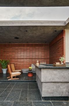 an outdoor kitchen and bar area with potted plants