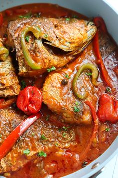 some fish and peppers are in a red sauce