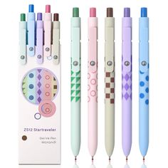 four different colored pens sitting next to each other in front of a box with the same design on it