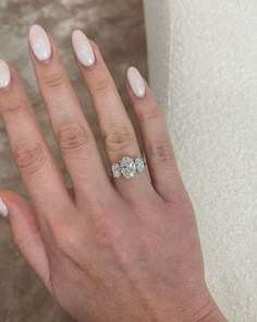 a woman's hand with two diamond rings on it