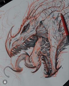 a drawing of a dragon with red pencils on it's face and tail