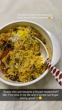 a white bowl filled with yellow rice on top of a table