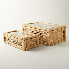 three wicker boxes sitting on top of a white table next to eachother