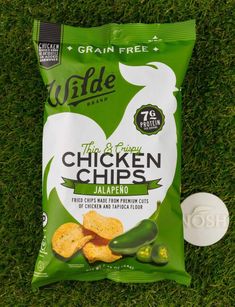 a bag of chicken chips sitting on top of grass next to a white frisbee