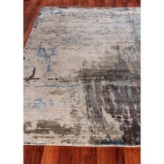 an area rug with wood flooring in the middle and a blue design on it