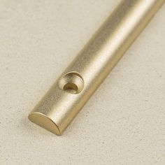 a gold colored metal object on a white surface