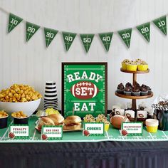 a football themed party with snacks and desserts on a table in front of a sign that reads ready set eat