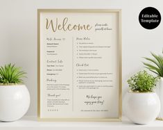 a welcome sign next to two potted plants on a white shelf with a gold frame