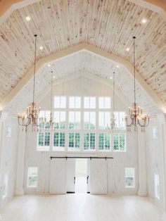 a large open room with chandeliers hanging from it's ceiling and windows